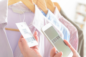 Woman scanning barcode with mobile phone