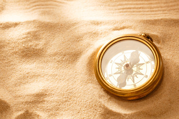 Golden compass with beach sand