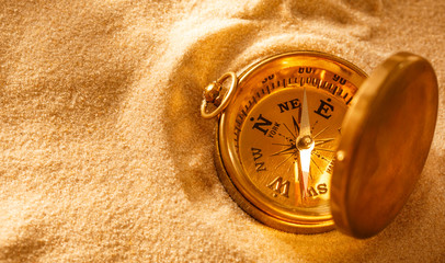 Golden compass with beach sand