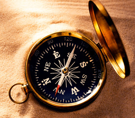 Golden compass with beach sand