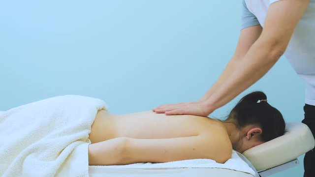The doctor massage the back og the girl in clinic