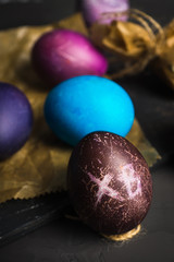 Rustic colored easter eggs on the dark stone background. Shallow depth of field.