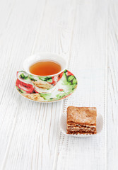 The piece of chocolate cake and a cup of tea on a white background. The concept of food and dessert.