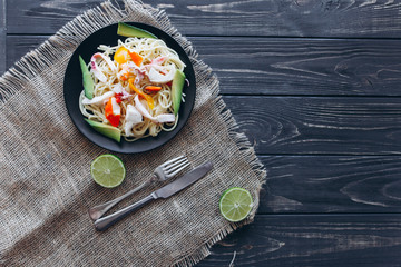 salad and pasta with seafood on wooden background