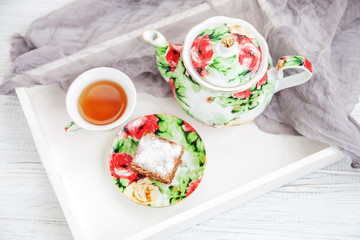 Cup of tea and piece of cake on a wooden tray. The concept of beverages and food.