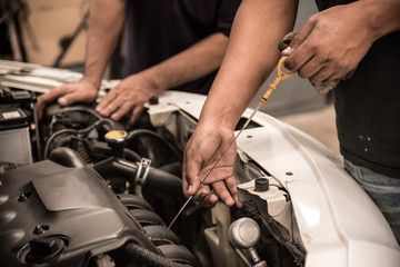 Close up man hands. Mechanic checking level of new engine oil .