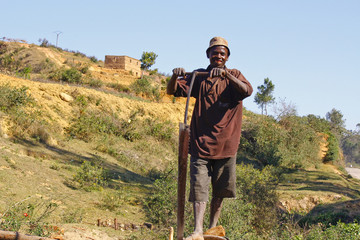 Poor malagasy men cutting timber in makeshift sawmill