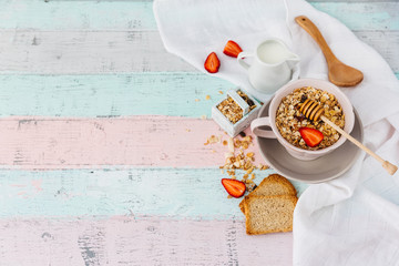 Oat flakes in bowl and fruits. Milk and honey. Wooden background. Top view