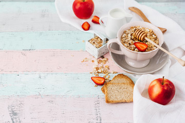 Oat flakes in bowl and fruits. Milk and honey. Wooden background. Top view