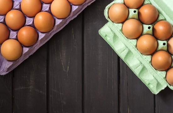 Brown chicken eggs in purple and light green carton