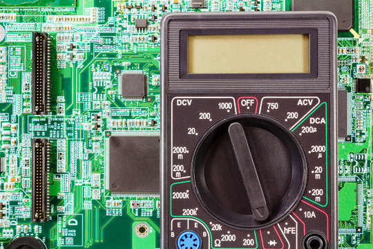 Digital multimeter on a printed circuit board closeup