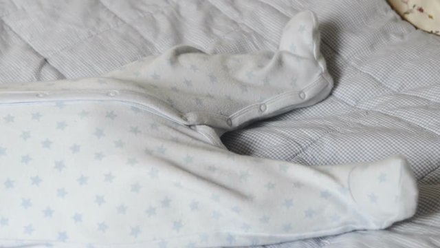 Little girl is lying on the bed, pulling legs and looking into the camera