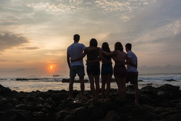 Girls Boys Friends Silhouetted Together Beach Ocean Sunrise Landscape.
