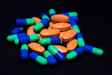 Medicine Pills. Tablets. Capsule.Pharmaceutical medicament, Close-up of pile of blue and green tablets - capsule. Pills and tablets on black background