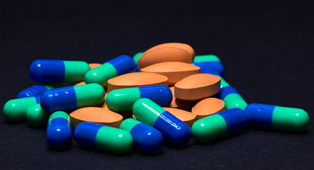 Medicine Pills. Tablets. Capsule.Pharmaceutical medicament, Close-up of pile of blue and green tablets - capsule. Pills and tablets on black background