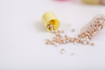 Yellow capsules on white background, one split open, copy space.