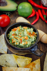 Guacamole with corn chips - nachos, made from avocado, tomatoes and lime.