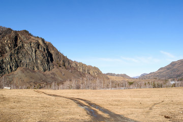 A dirt road in the mountains on a spring sunny day