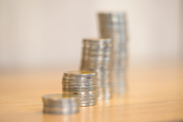 Stacking money for growing chart of coins on wooden desk.
