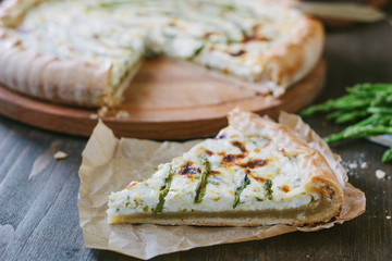 Piece of delicious asparagus pie on list of parchment.