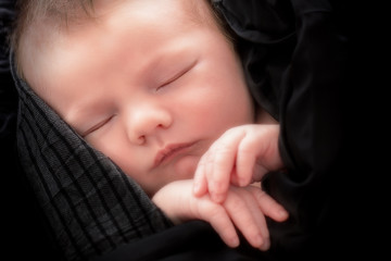 beautiful baby looking out from under blanket