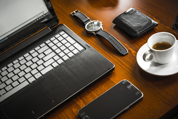 Laptop computer, coffe, watch, glasses and wallet on wooden desk