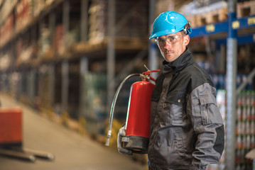 Caucasian warehouse worker with fire extinguisher