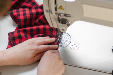 Hands seamstress at the sewing machine