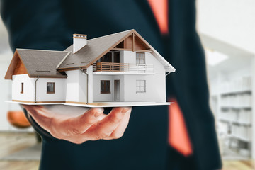 Close-up image of businessman holding a 3d house, architecture project