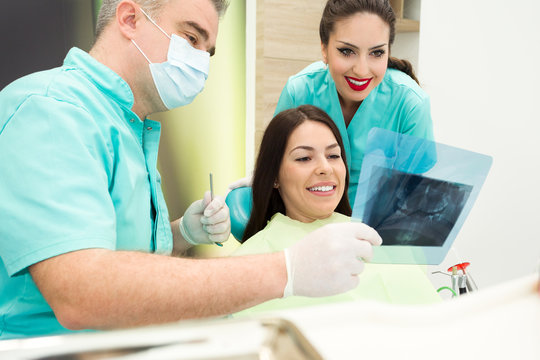 Dentist is examining x-ray of the teeth