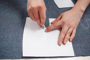 Seamstress hands on the work table with pattern.