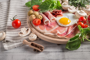 Healthy Mediterranean breakfast ingredients, ham, fried eggs, tomatoes