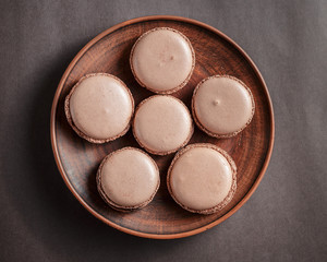 Chocolate pastel brown Macarons or Macaroons on a plate