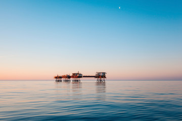 Silhouette of offshore oil platform at sunset 