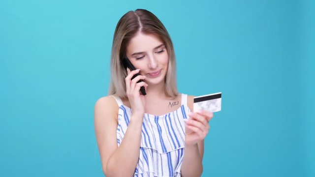 Beautiful young blonde woman using a credit card to make a purchase