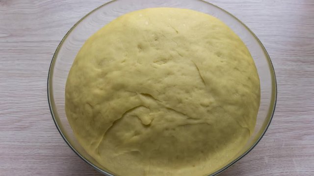 Yeast dough (pastry) raising in glass bowl, time lapse video