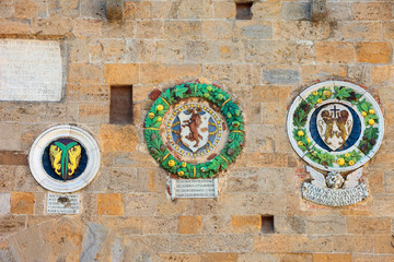 Volterra, Palazzo dei Priori detail of facade with ancient crests, Pisa, Tuscany, Italy