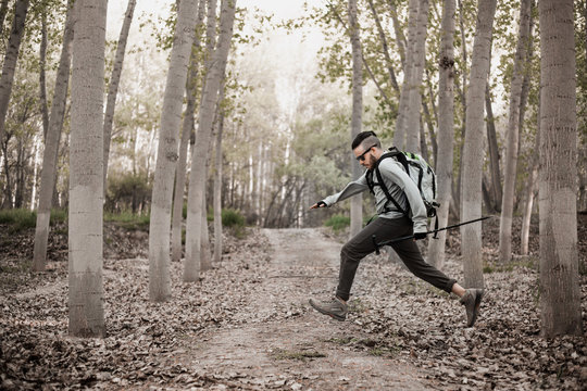 Young Backpacker Man Running Through The Forest