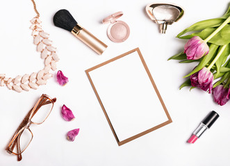 Woman's accessories and pink tulips on white background