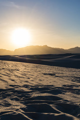 setting sun over the sand dunes and mountains