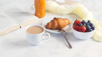 Morning Coffee mug with croissant, juice and fresh berries, cozy and tasty breakfast. Selective focuse