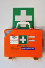 Erste-Hilfe-Koffer in Wandhalterung mit Rettungszeichen für Erste Hilfe