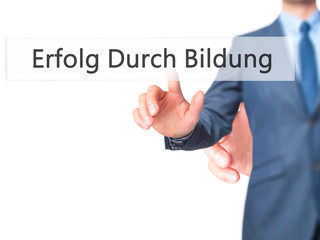 Erfolg Durch Bildung (Success Through Training in German) - Businessman hand pressing button on touch screen interface.