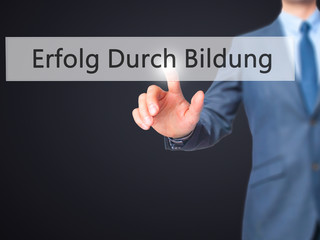Erfolg Durch Bildung (Success Through Training in German) - Businessman hand pressing button on touch screen interface.