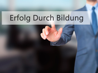 Erfolg Durch Bildung (Success Through Training in German) - Businessman hand pressing button on touch screen interface.
