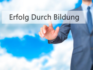 Erfolg Durch Bildung (Success Through Training in German) - Businessman hand pressing button on touch screen interface.