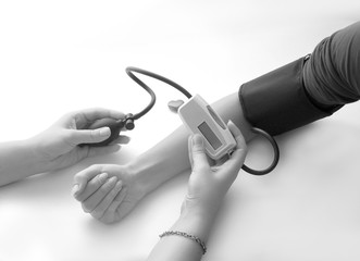 Measurement of blood pressure. Doctor measuring blood pressure of a patient, selective focus.
