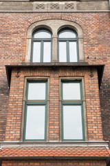 Vintage design windows with a balcony  on the brick facade of the old house
