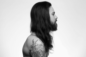 bearded man with long hair and tattoo