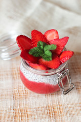 Chia pudding with strawberries in small bowls on a linen tablecloth